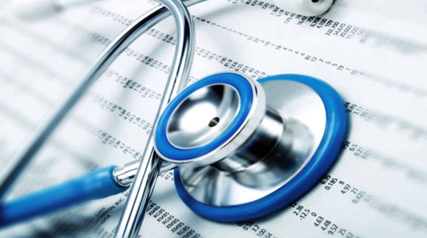 A stethoscope and some papers on top of a table.